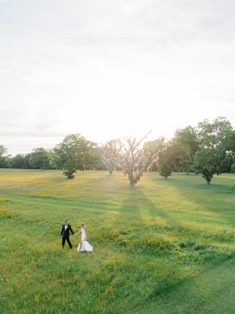 Bride and groom sunset portraits at Agapae Oaks. Yellow wildflowers and golden sun shining through spanish moss. 