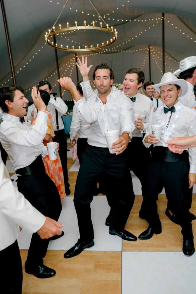 Groom dances with groomsmen. 