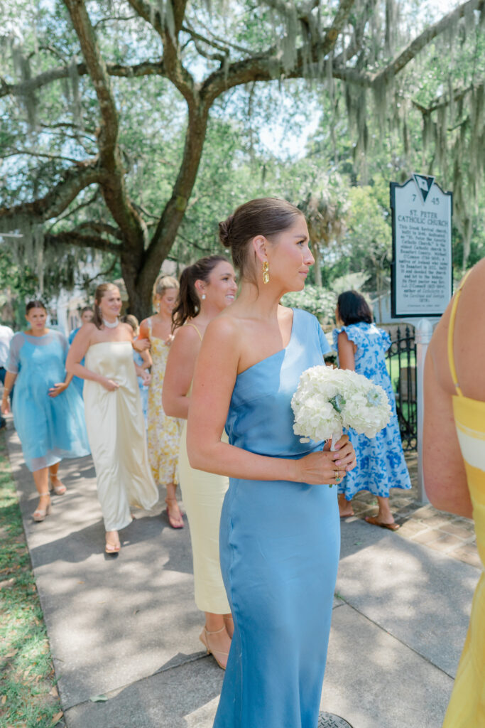 Bridesmaids arrive to the chapel in downtown Beaufort. Bridesmaids wearing mix-matched blue and yellow dresses. 