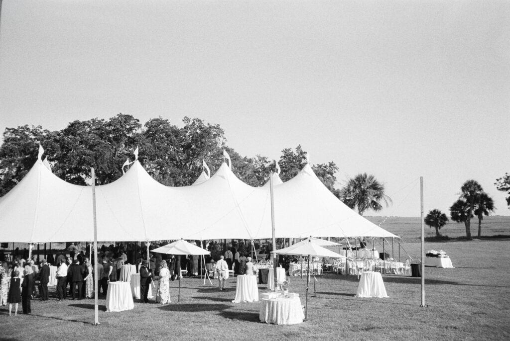 Cocktail hour begins at Agapae Oaks wedding ceremony. Black and white film photo.