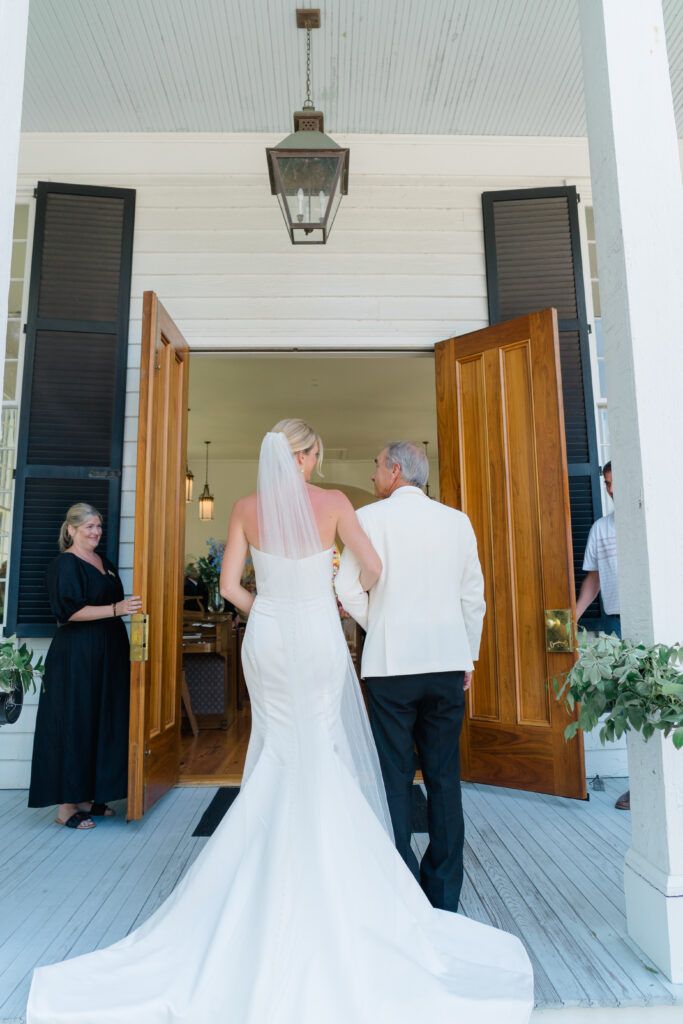 Father of the bride looks at daughter before entering intimate wedding ceremony. 