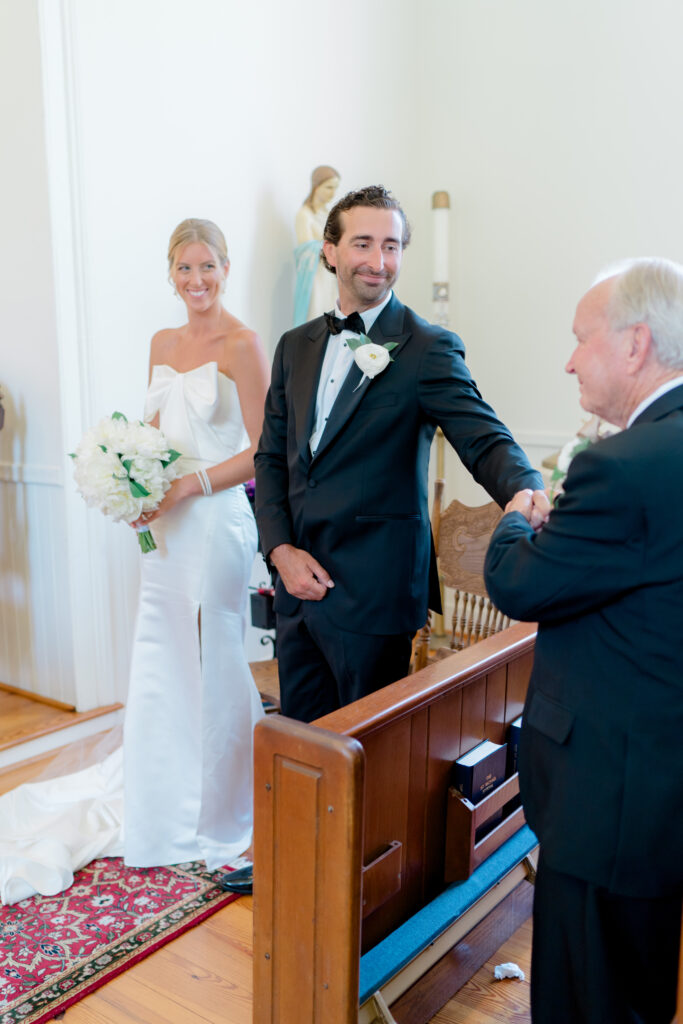 Groom reaches out to his uncle during wedding ceremony. 