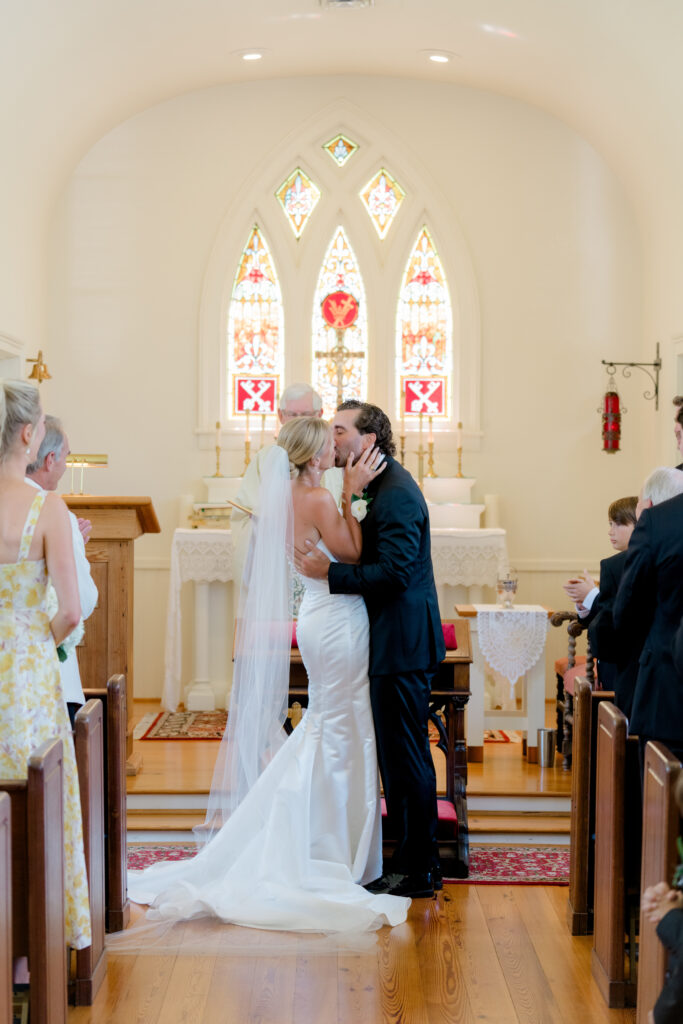 First kiss at wedding ceremony. Bride and groom kiss.