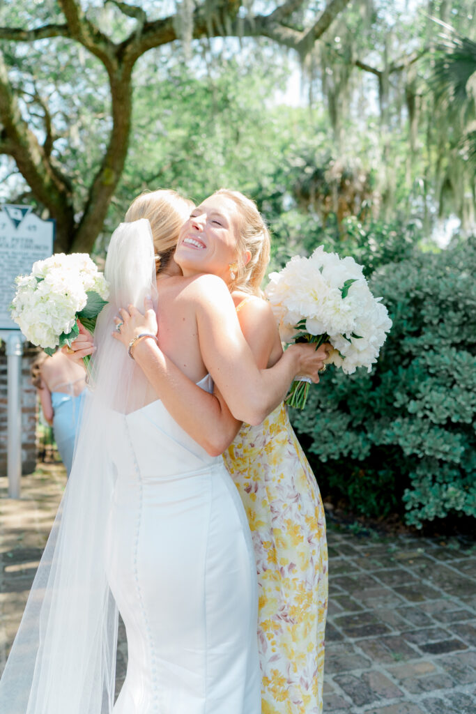 Bride hugs bridesmaid immediately after wedding ceremony. 