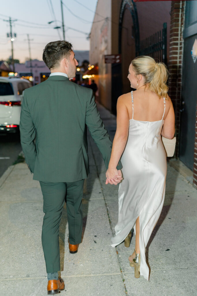 Flash photo of bride and groom walking in downtown Charleston to their wedding welcome party. 