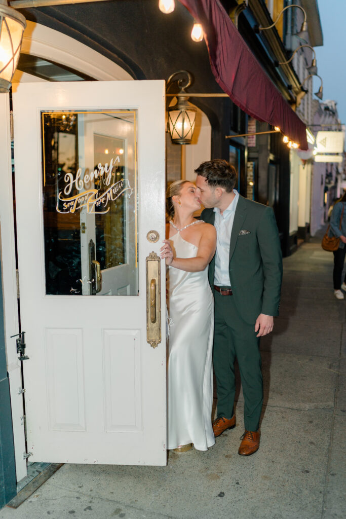 Bride and groom kiss before going in the door at wedding welcome party. 