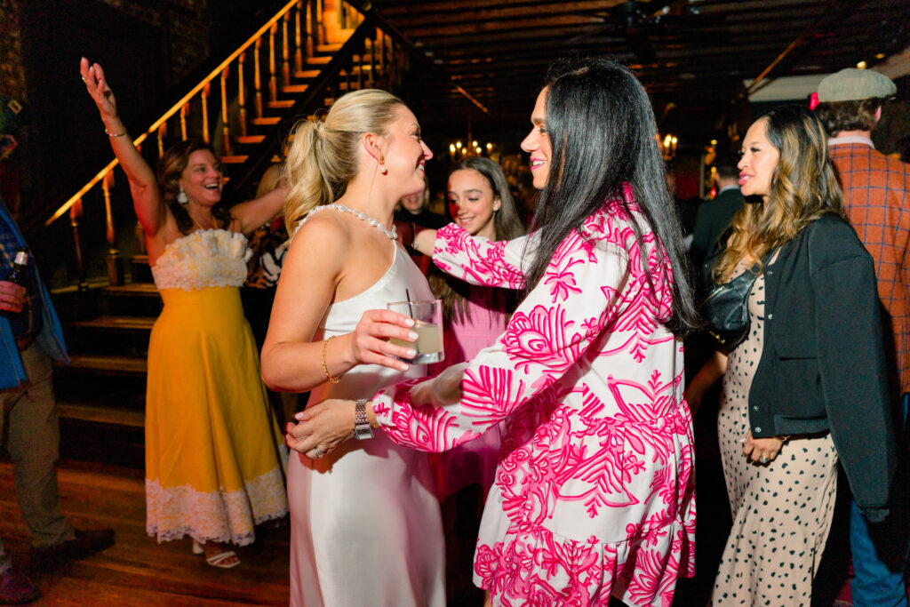 Bride greets guests. Pink and yellow dresses. 