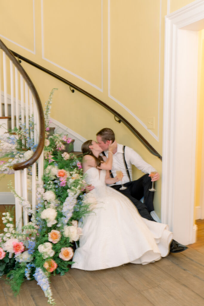 Bride and groom kiss of the curved staircase at Lowndes Grove. 