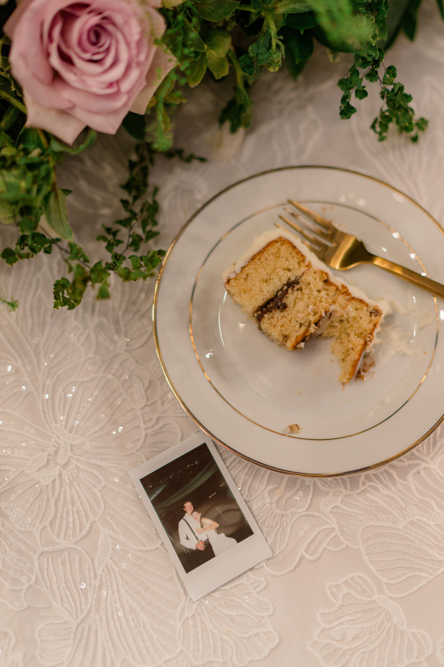 Eaten piece of cake with polaroid on head table. 