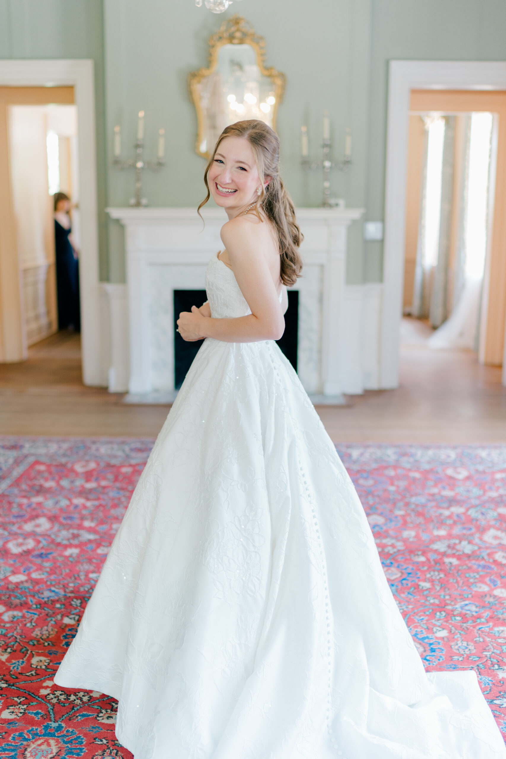 Candid photo of bride looking back at camera before first look with bridesmaids upstairs at Lowndes Grove.