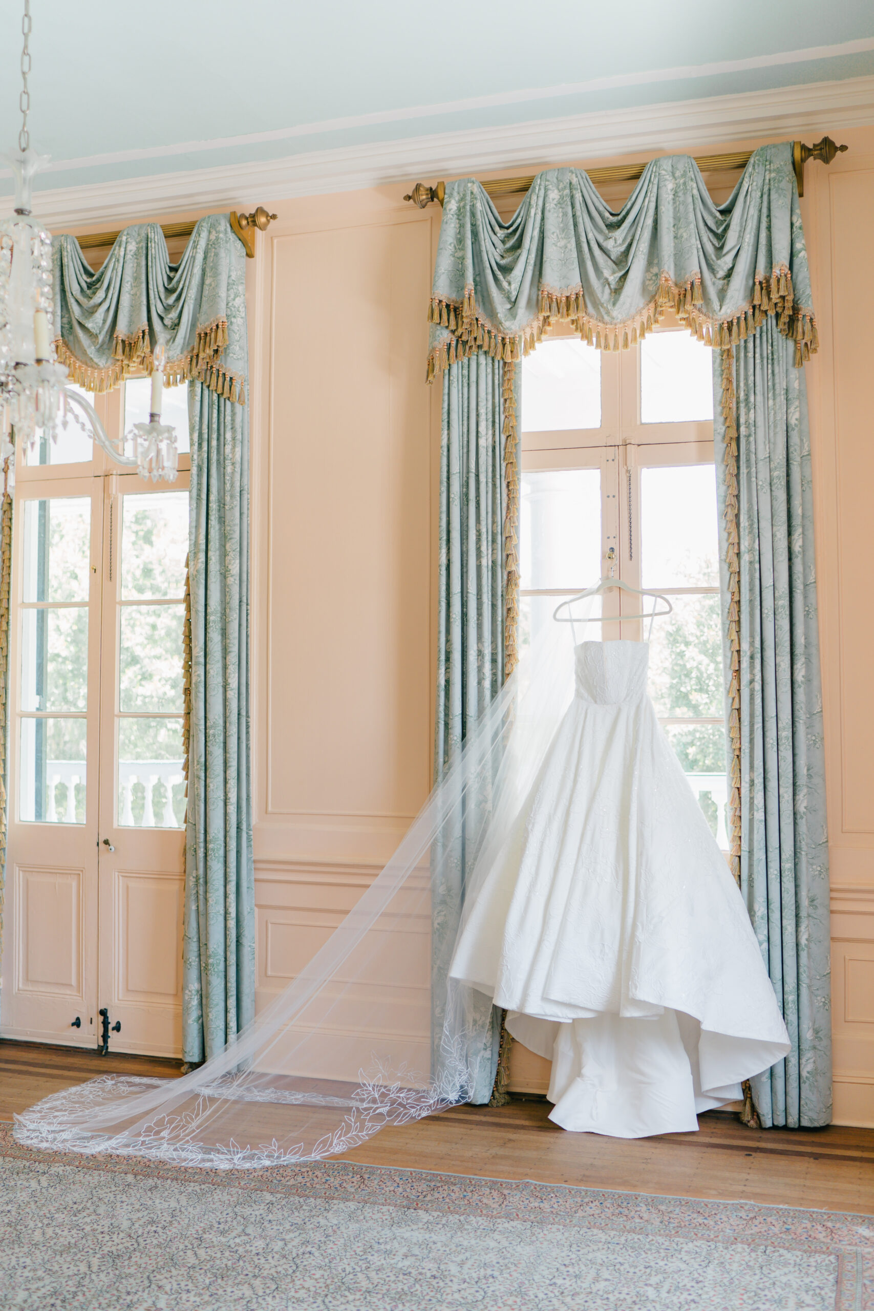 Wedding dress hanging in Lowndes Grove. Historic drapes with gold tassels. 