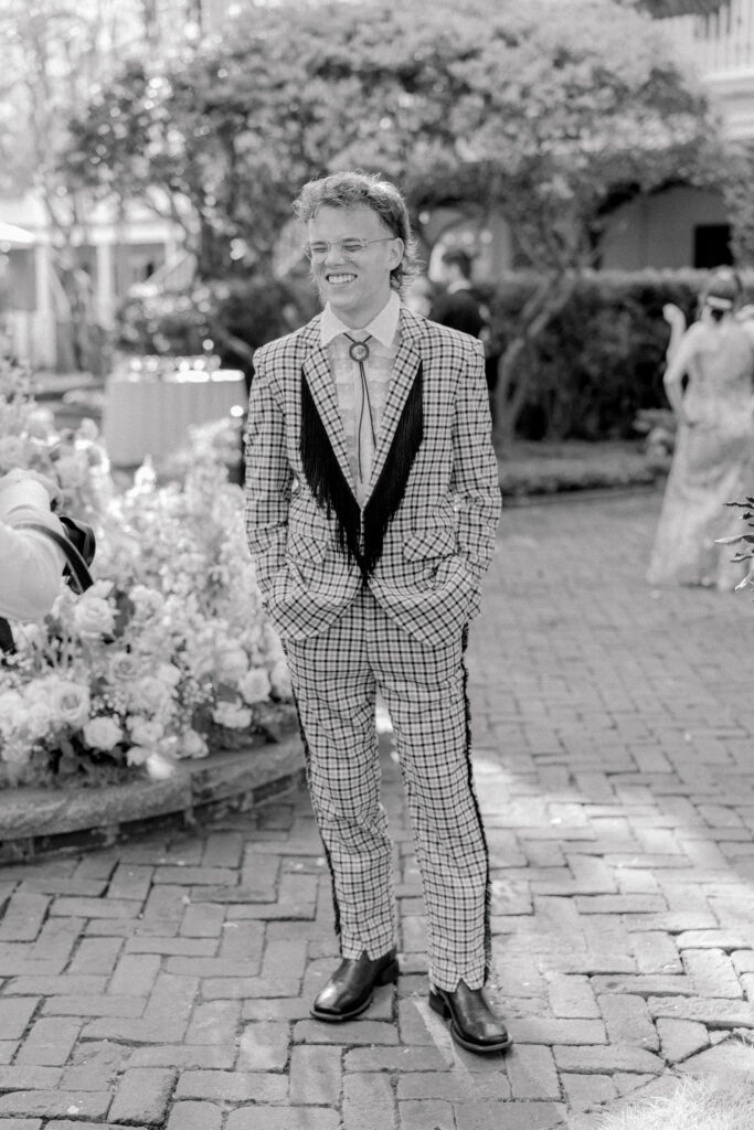 Groom in bolo tie and suit jacket with frill lapel. 