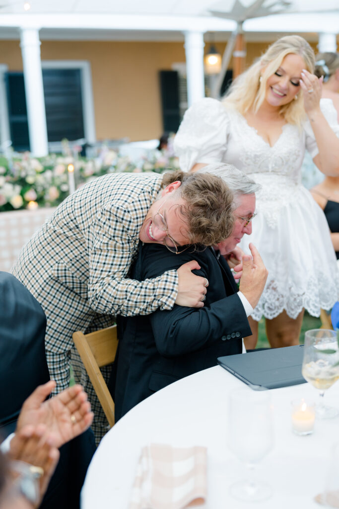 Groom hugs father of the bride after wedding welcome speech. 