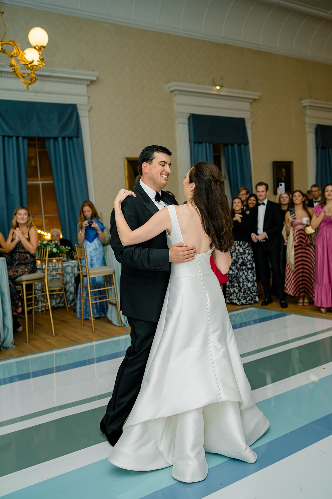 First dance at Hibernian Hall with custom blue drapes in background. Blue, green, and white custom dance floor. 