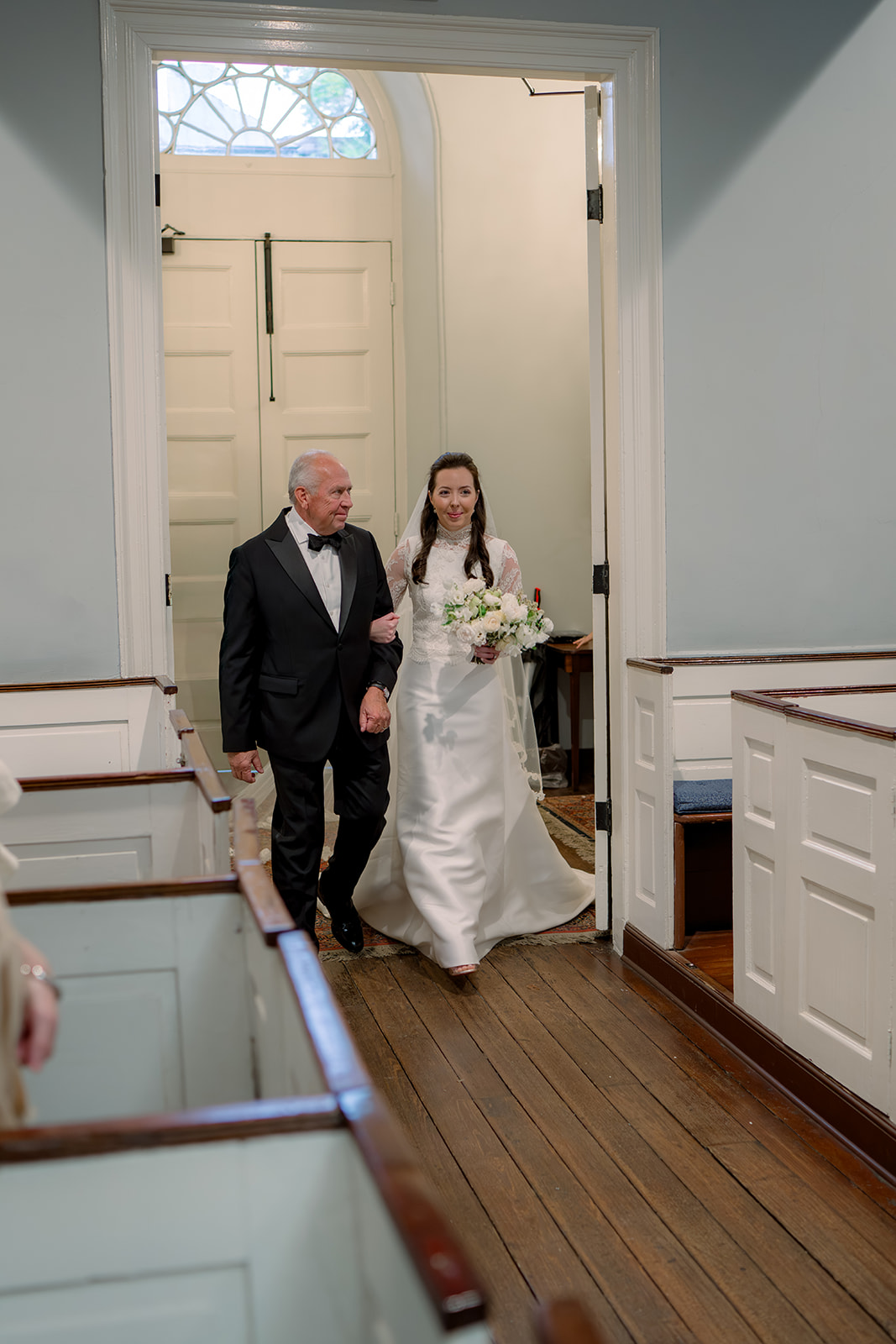 Father of the bride smiles at his daughter entering wedding ceremony. 