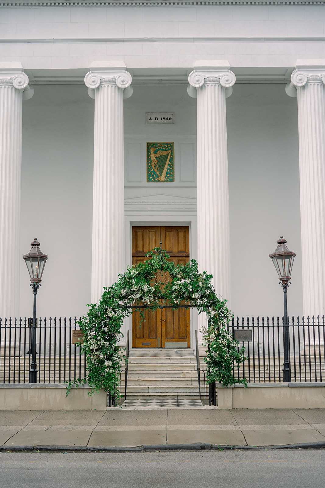 Hibernian Hall winter wedding. Big greenery arch with touches of white flowers on front gate. 