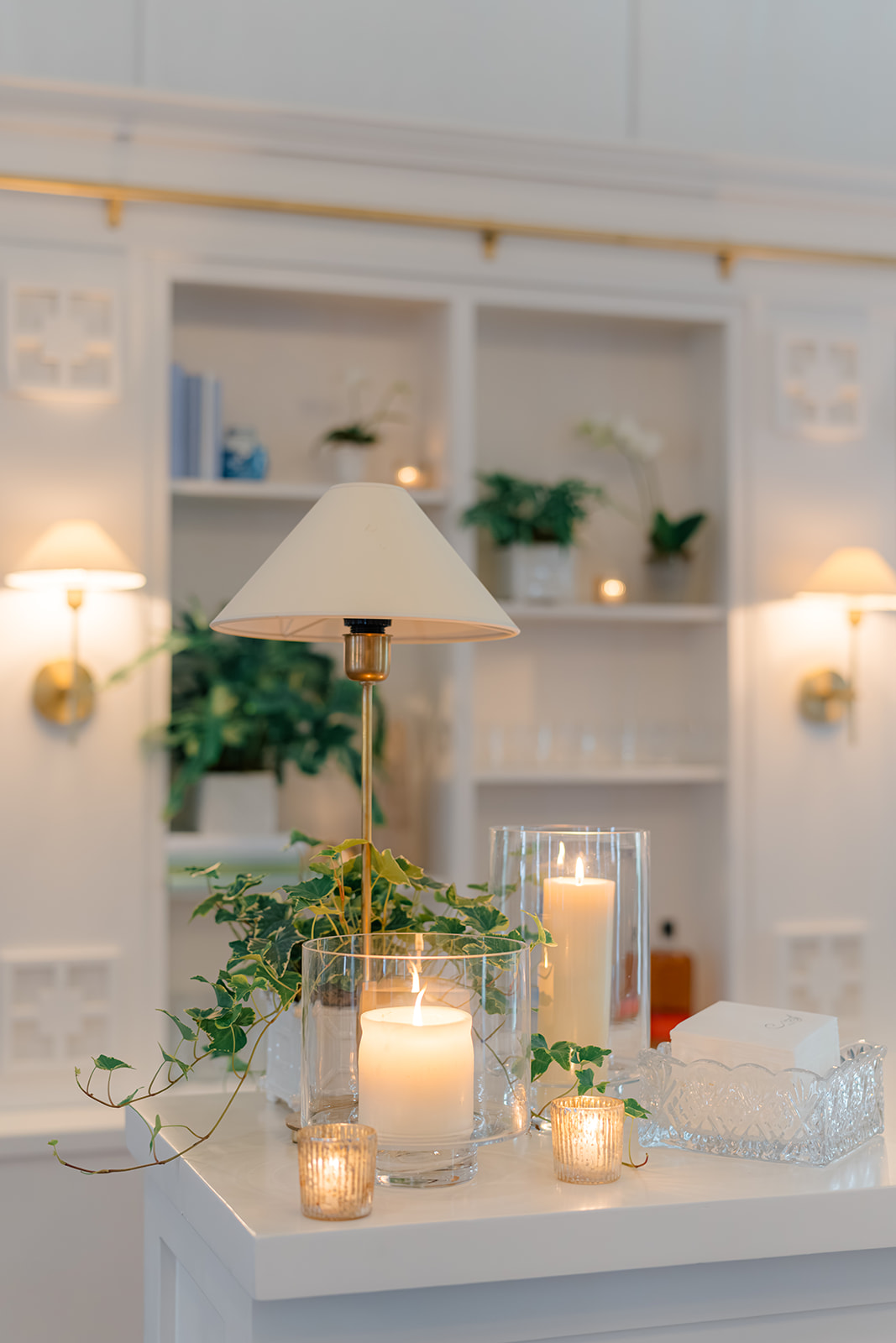 Lamp and candles on bar with custom bookshelf in background. 