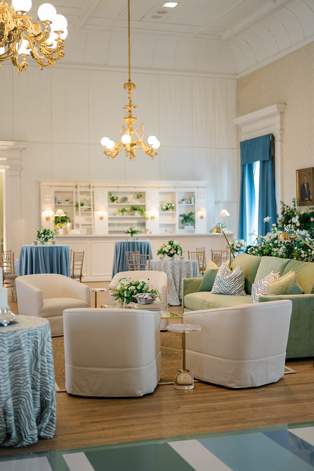 Living room style wedding reception seating with custom bar-bookshelf in background. Blue, Green, and white wedding. 