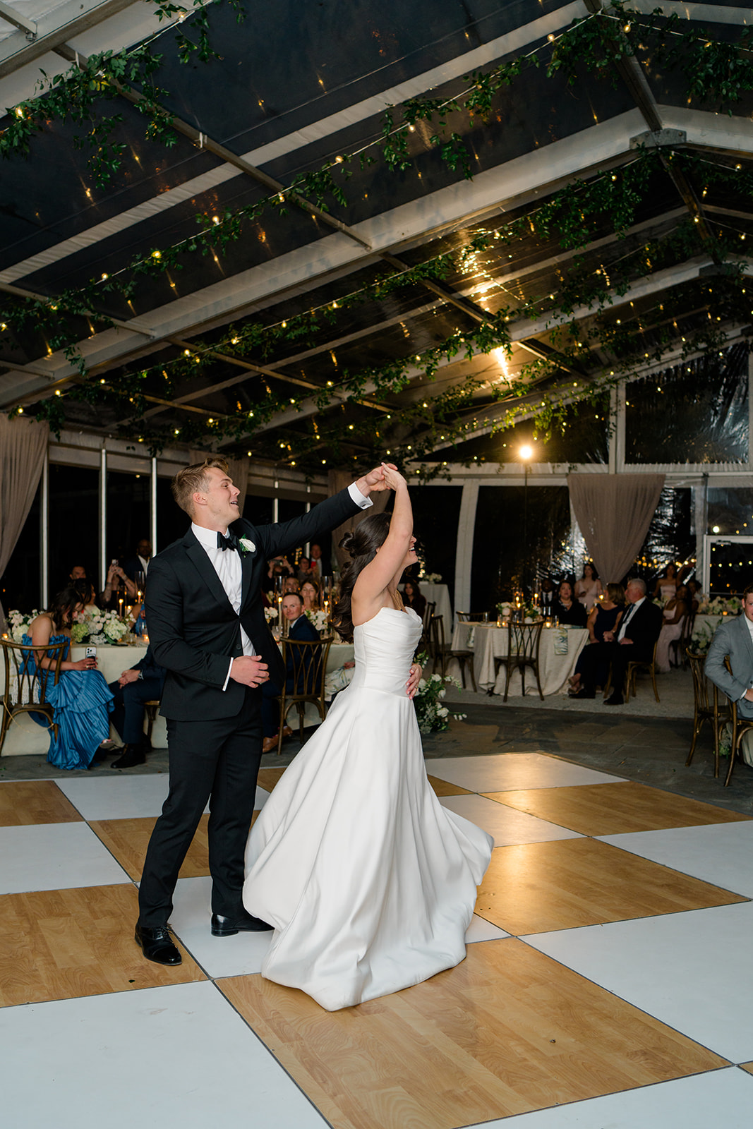 Bride and groom first dance at Lowndes Grove. White and light wood checkerboard dance floor.