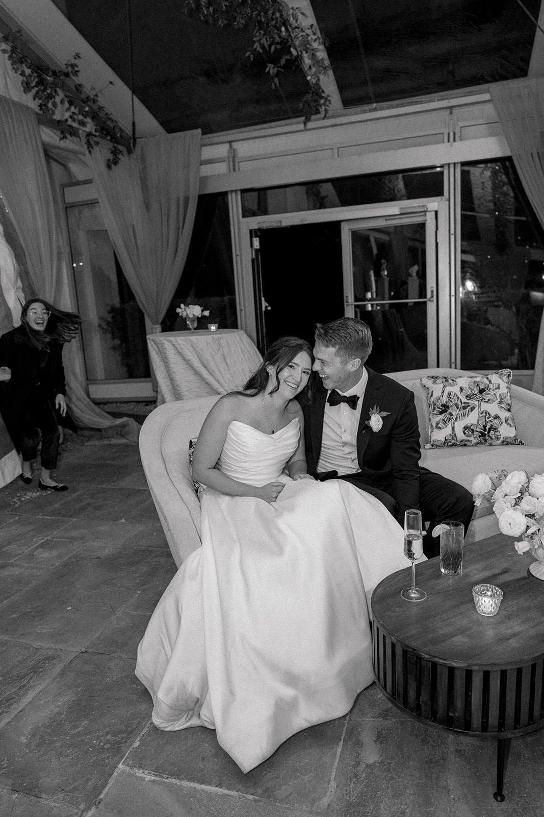 Bride and groom sitting on couch during wedding speeches. 