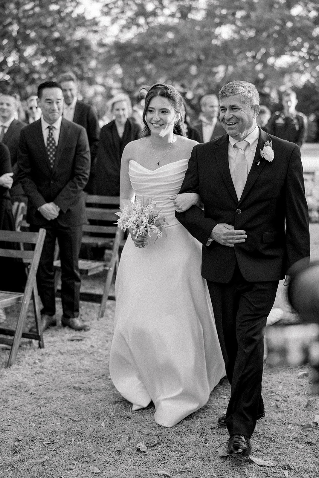 Happy father of the bride walking daughter up the aisle at outdoor Charleston wedding ceremony. 