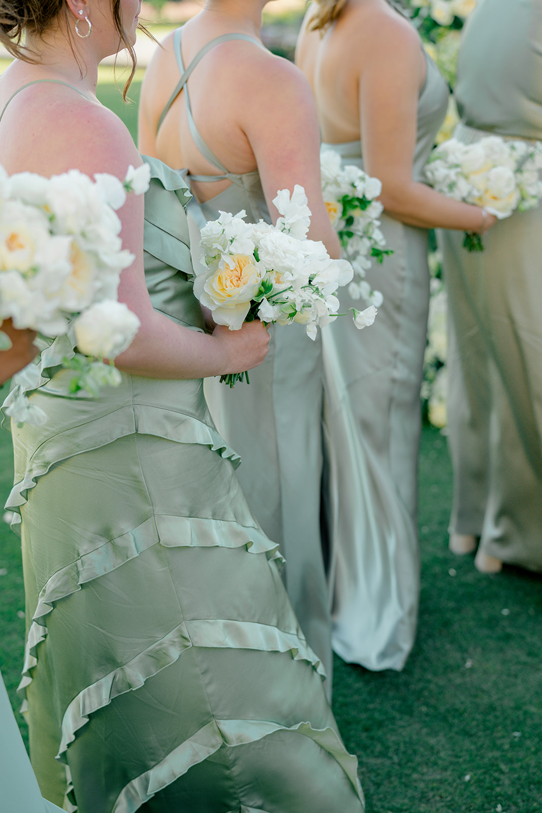 bridesmaids in light green dresses at outdoor wedding ceremony. 