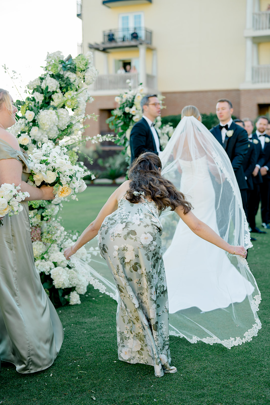 Maid of honor spreads the veil during fall destination wedding. 