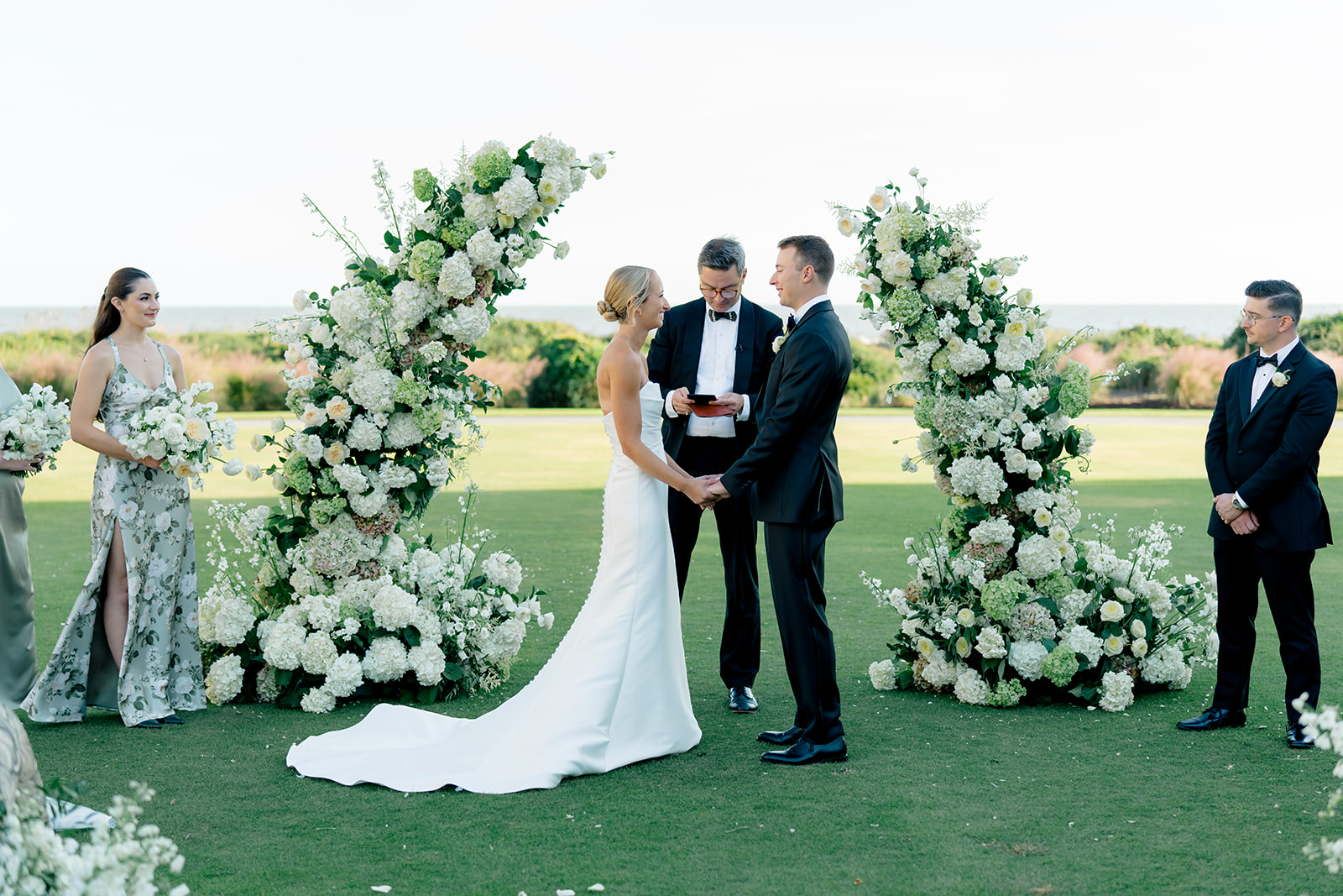 Bride and groom smile with each other during wedding vows. 