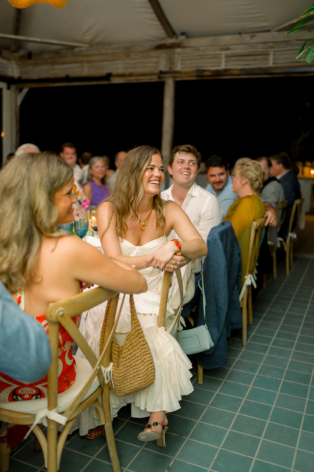 Bride laughs during speeches at rehearsal dinner. 