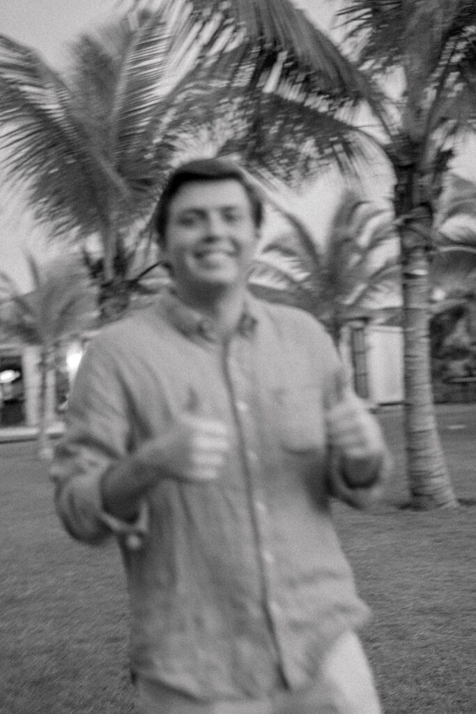 Blurry black and white photo of groom giving thumbs up.