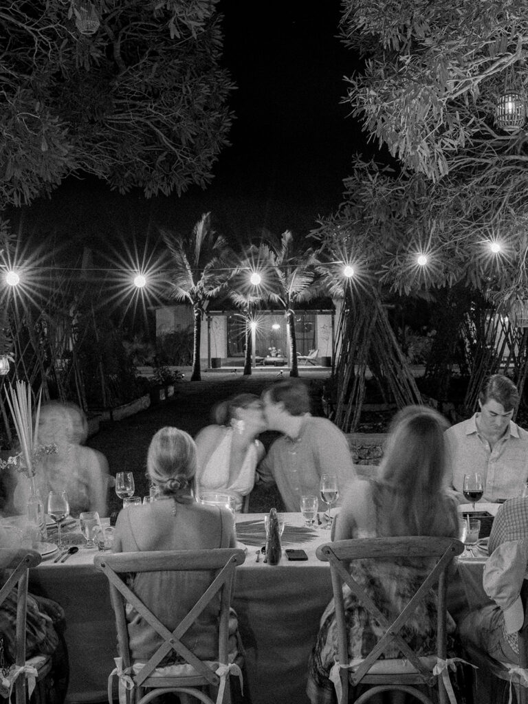 Bride and groom kiss at the head table. 