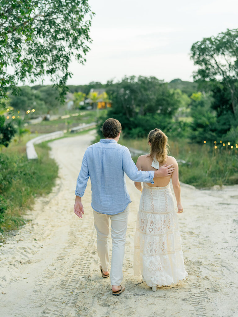 Bride and groom walking together on dirt path to wedding welcome dinner in the bahamas. Winter wedding.