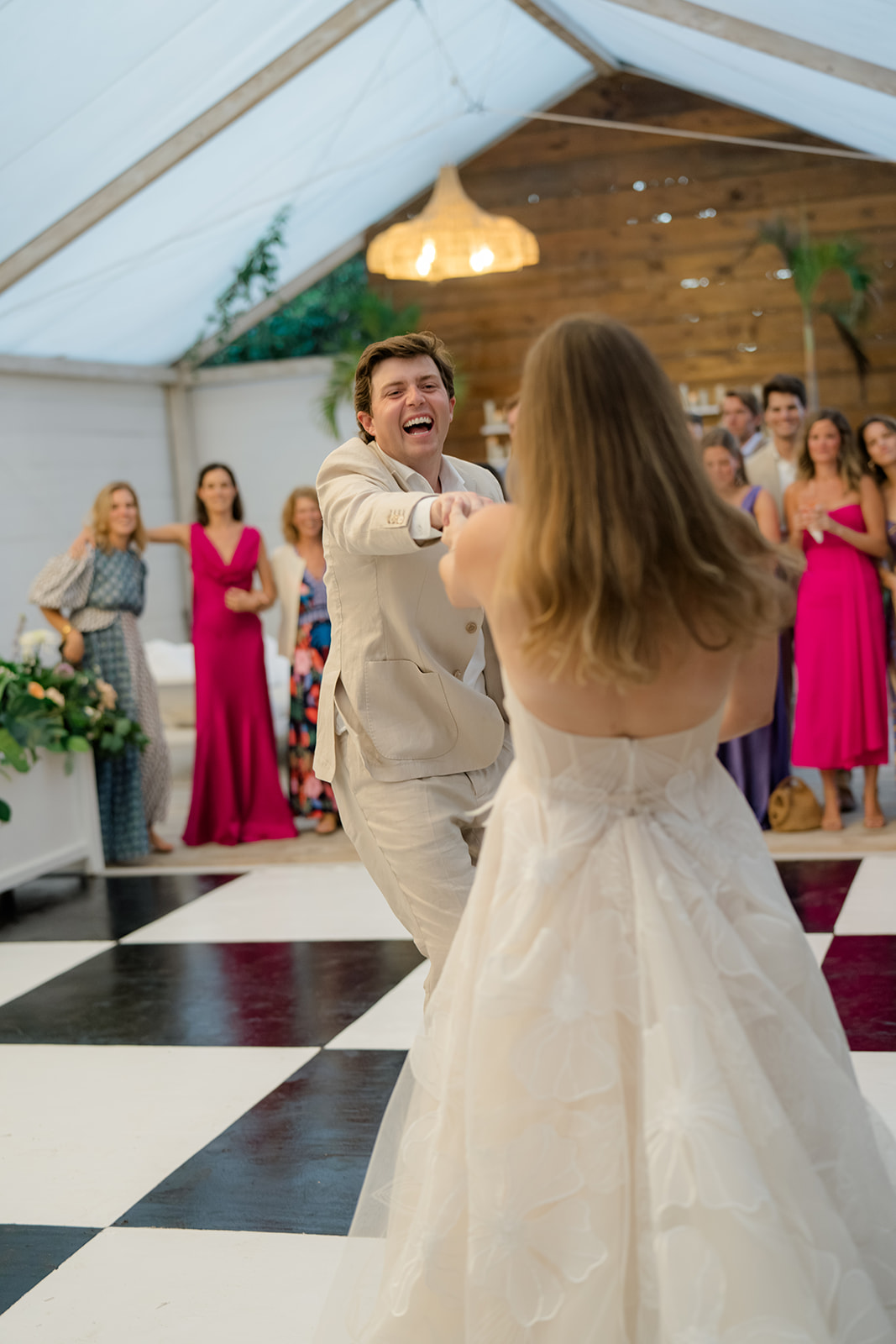 Groom laughs at bride during first dance. 