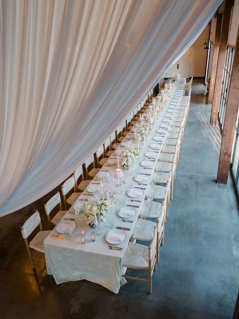 Long head table with white and light blue draping. 
