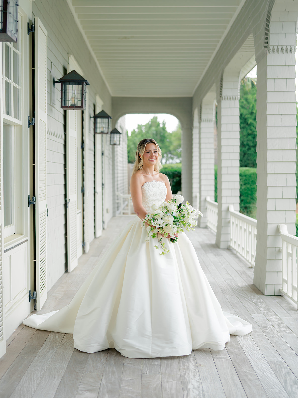 Bride in strapless dress on the porch at the Ocean Course. 