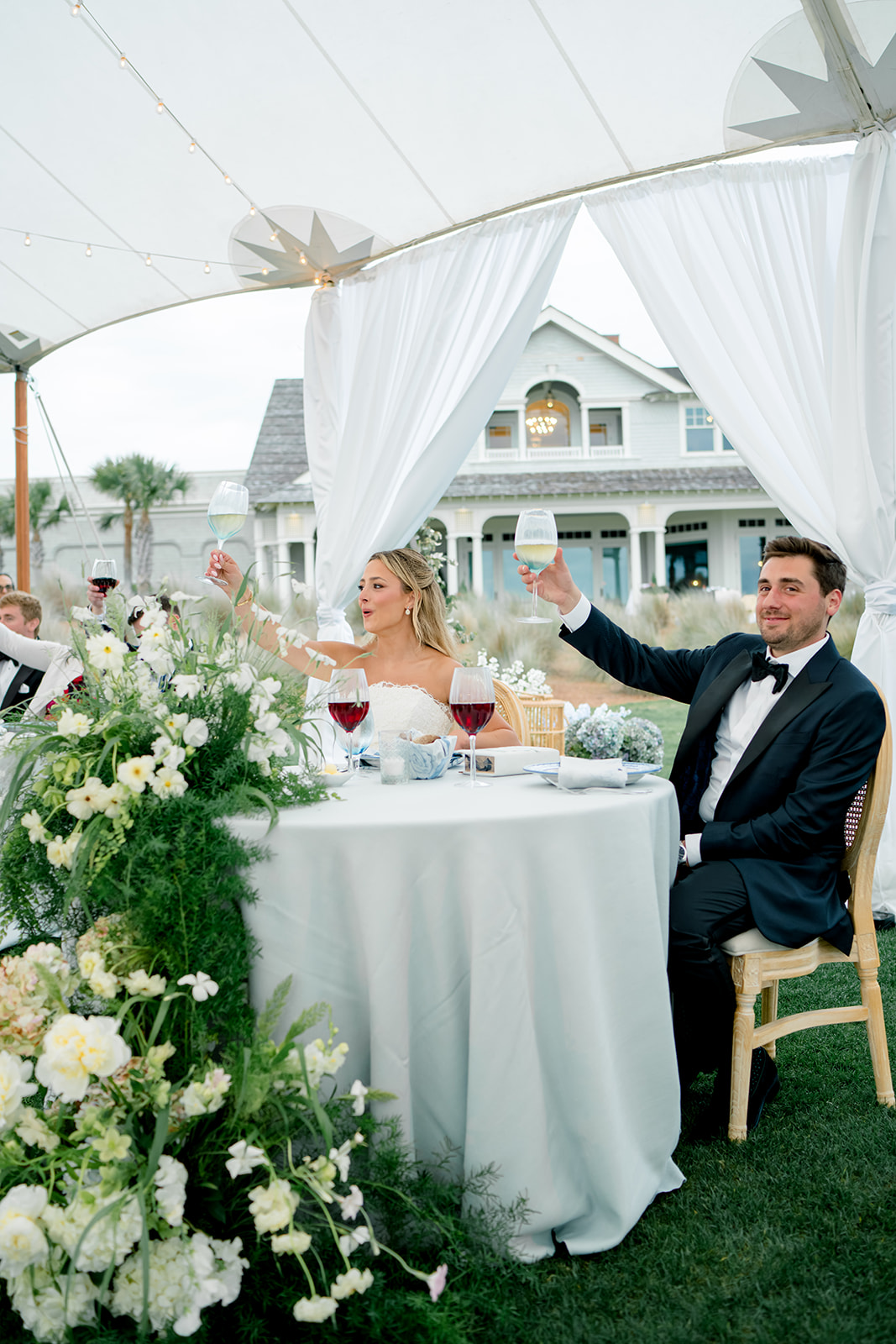 Bride and groom raise their glasses after father of the bride welcome. 