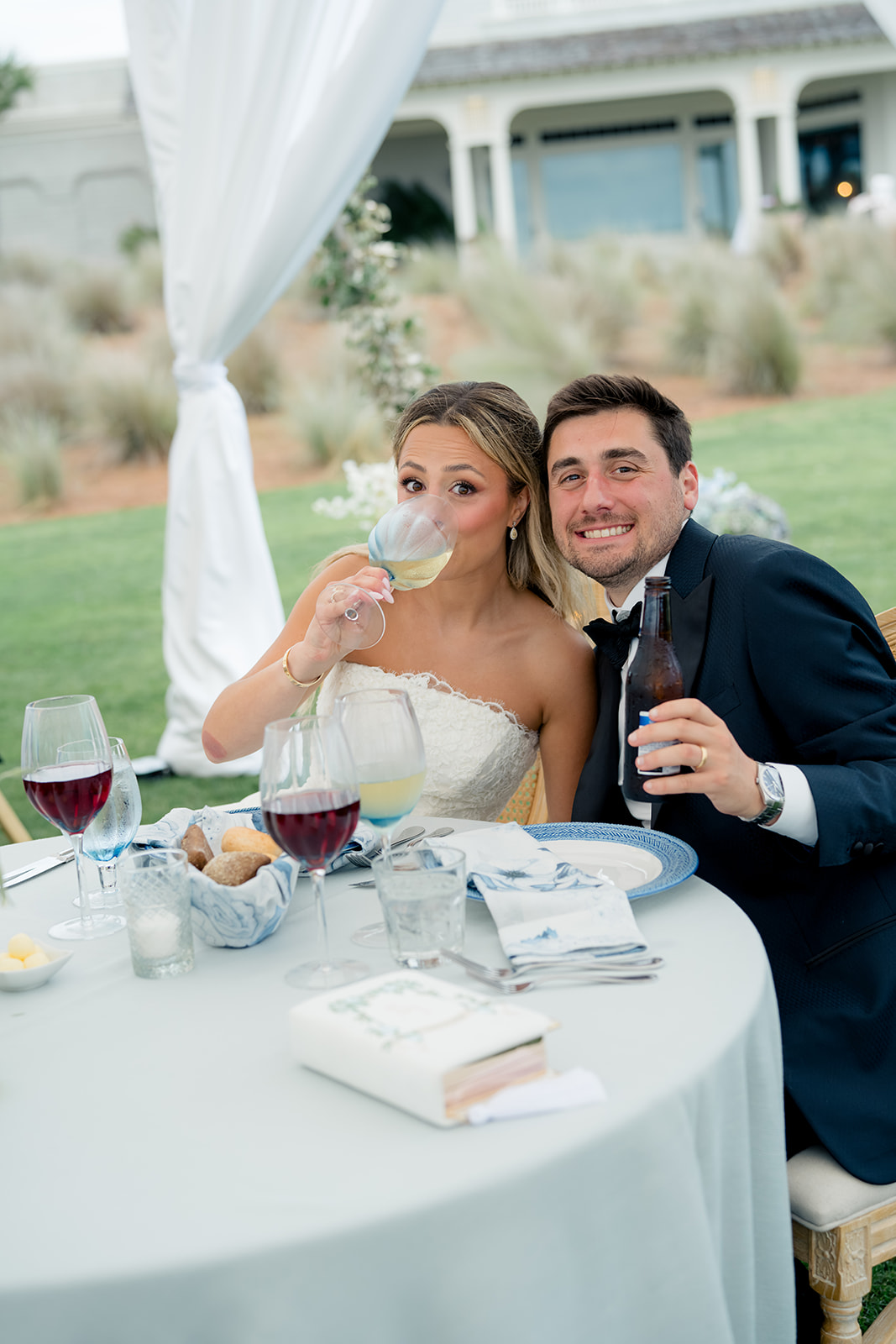 Fun candid of bride and groom at sweetheart table. 