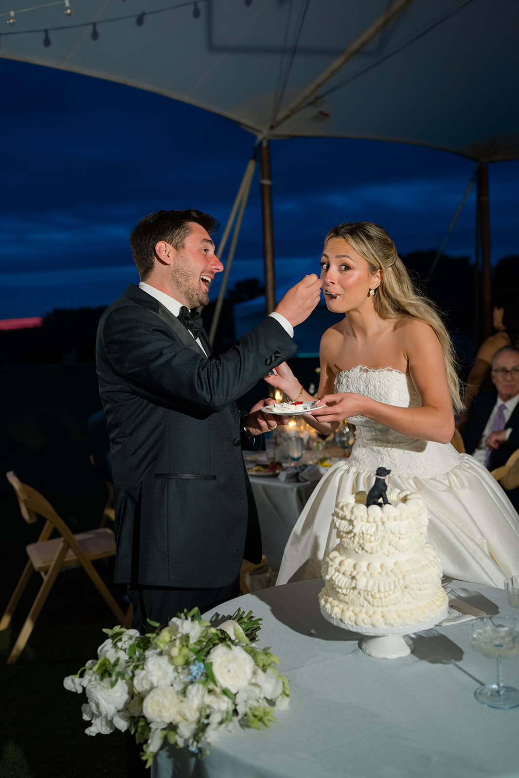 Groom feeds bride wedding cake. 