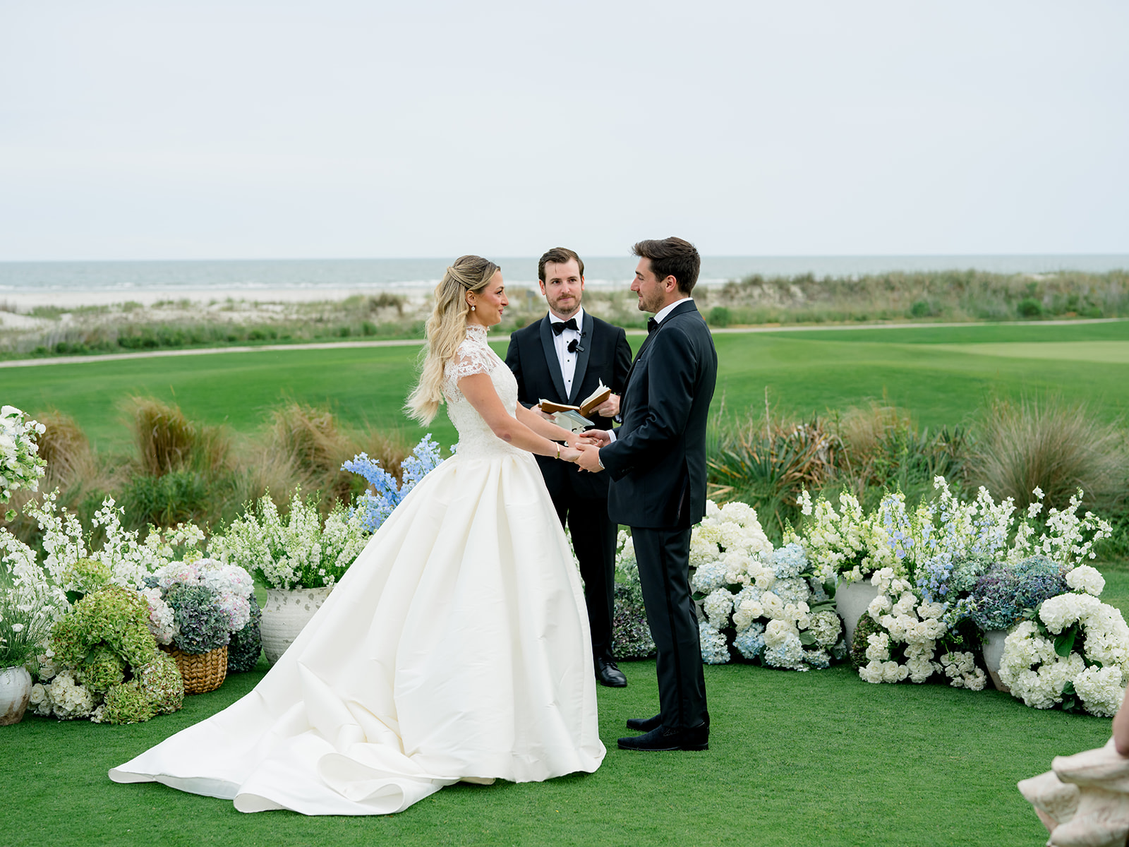 Bride and groom vow exchange during ceremony. Spring Kiawah Wedding.