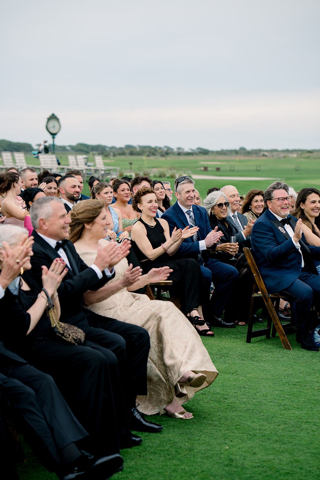 Wedding guests clap during wedding ceremony first kiss.
