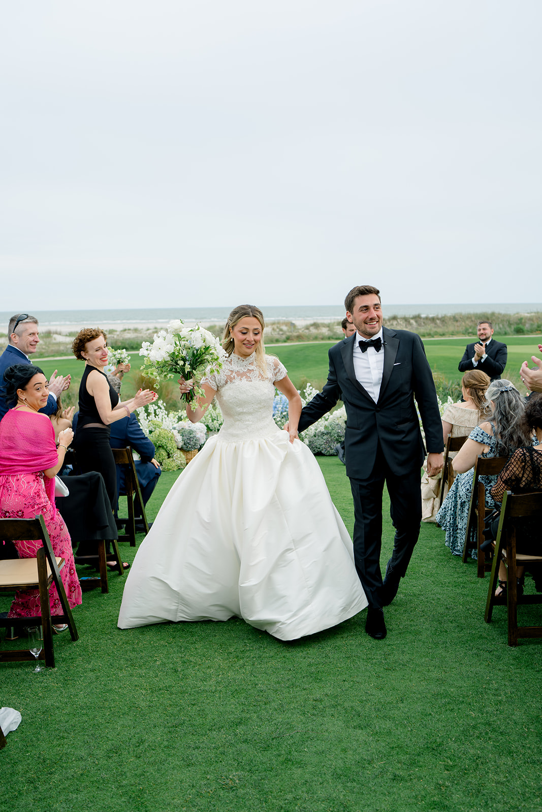 Bride and groom walking down the aisle. Bride wearing removable lace top.