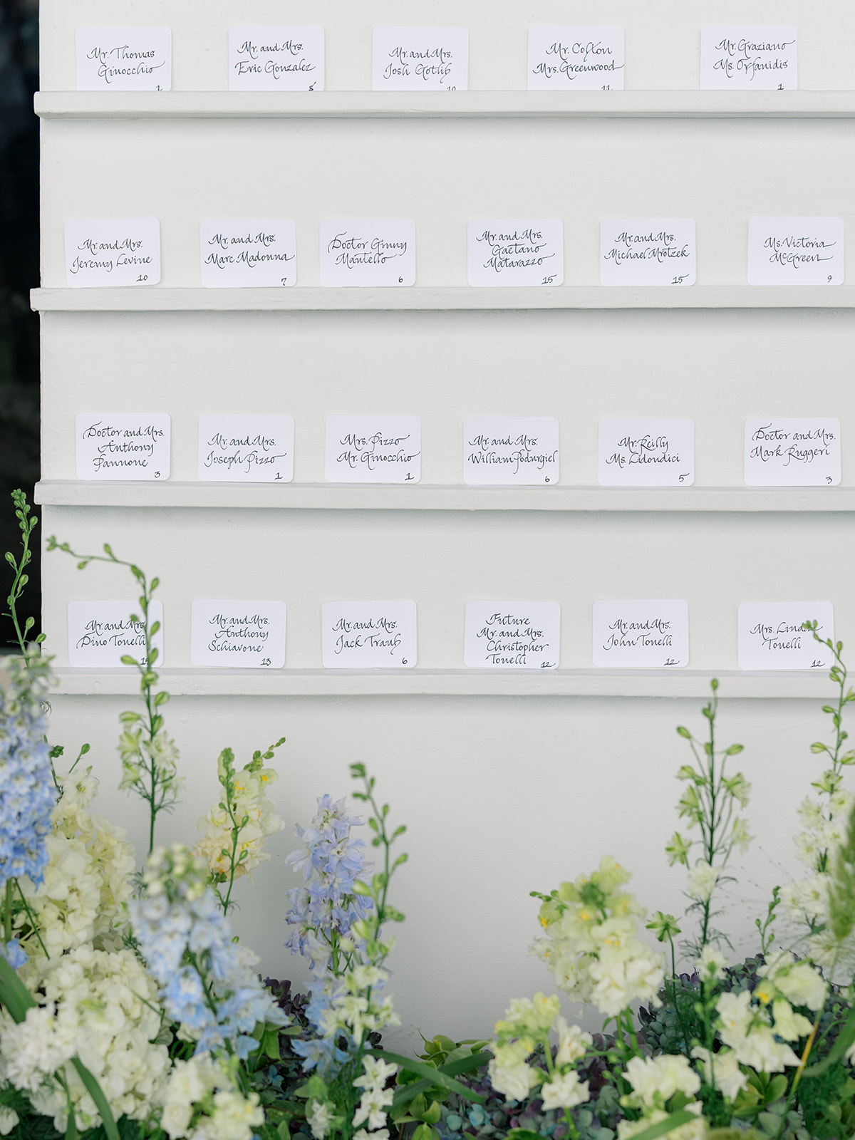 Handwritten reception seating charting with blue and white flowers. 