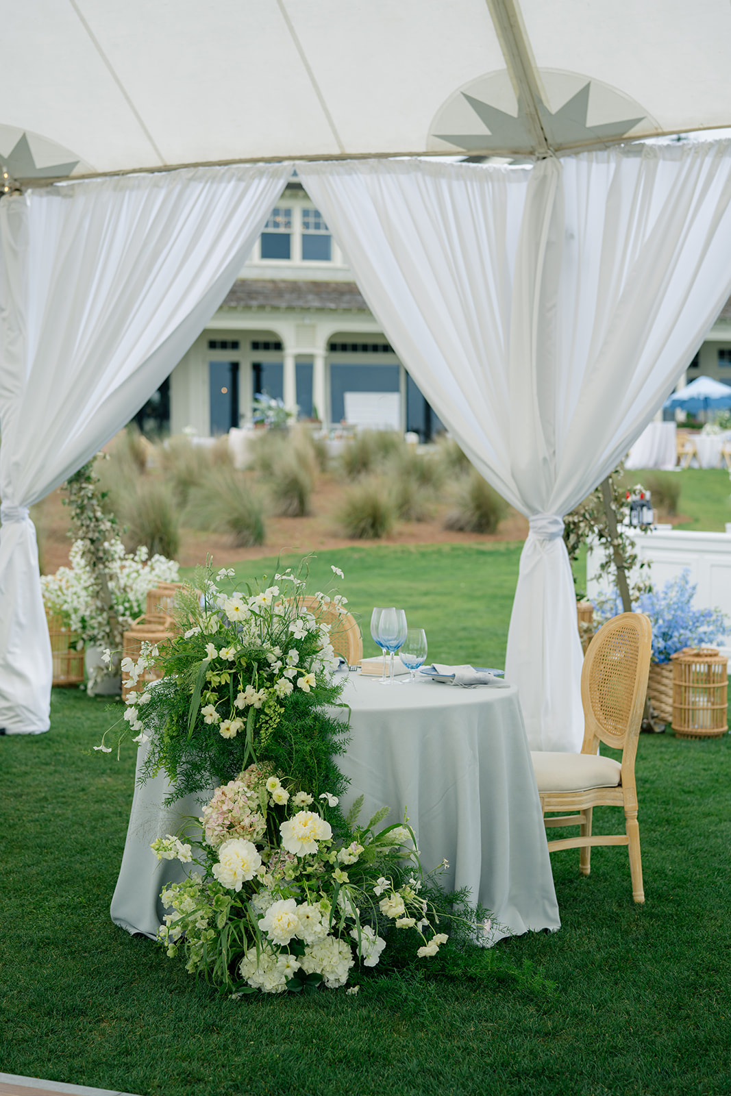 Sweetheart table with overflowing white flowers and light blue table linen