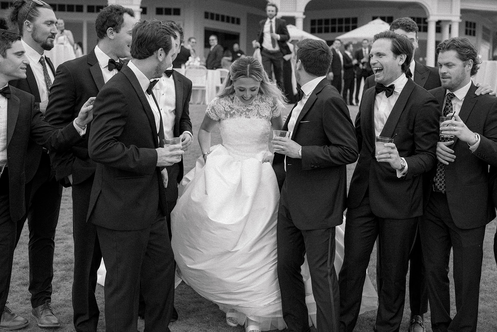 Bride joins group photo of grooms friends.