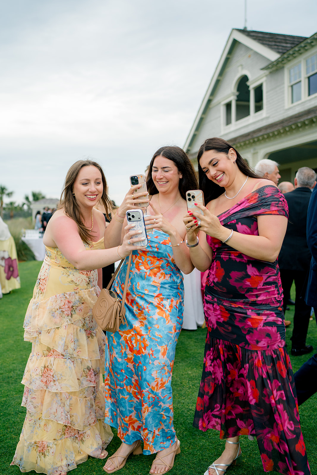 Friends take pictures of the bride at cocktail hour. 