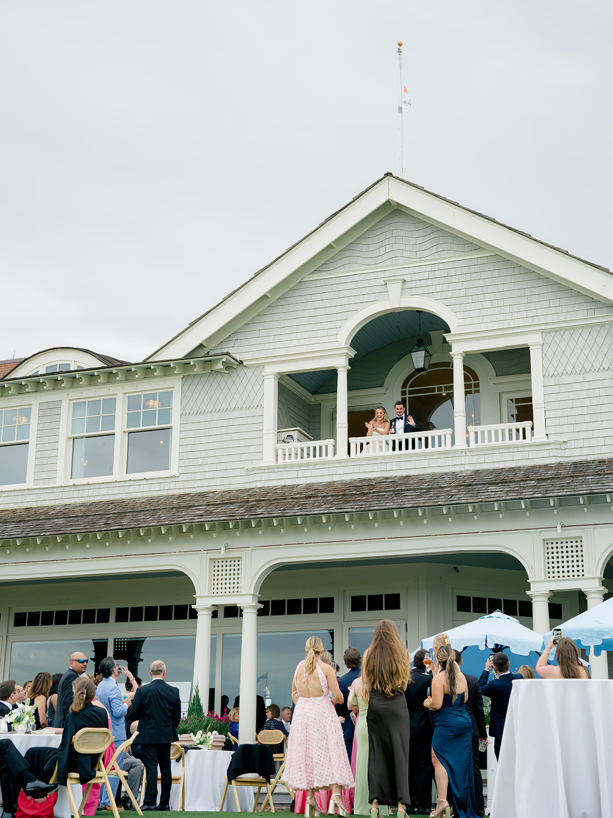 Bride and groom wave from top porch. 