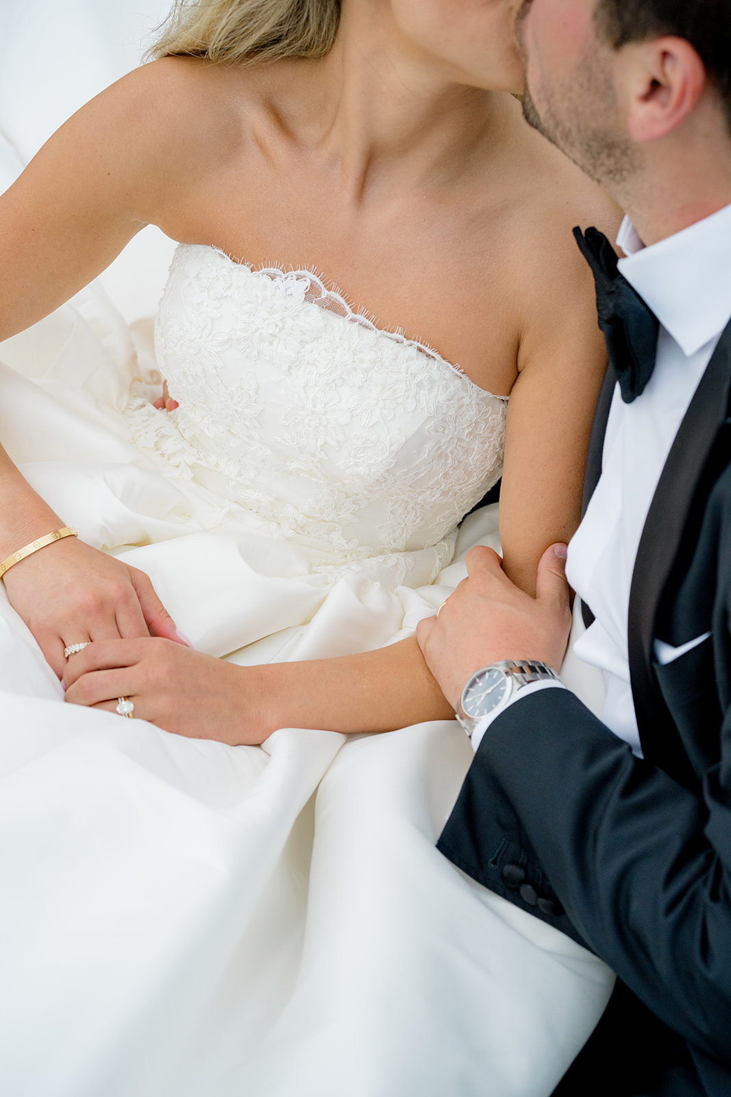 Bride and groom kiss with groom holding brides arm. 