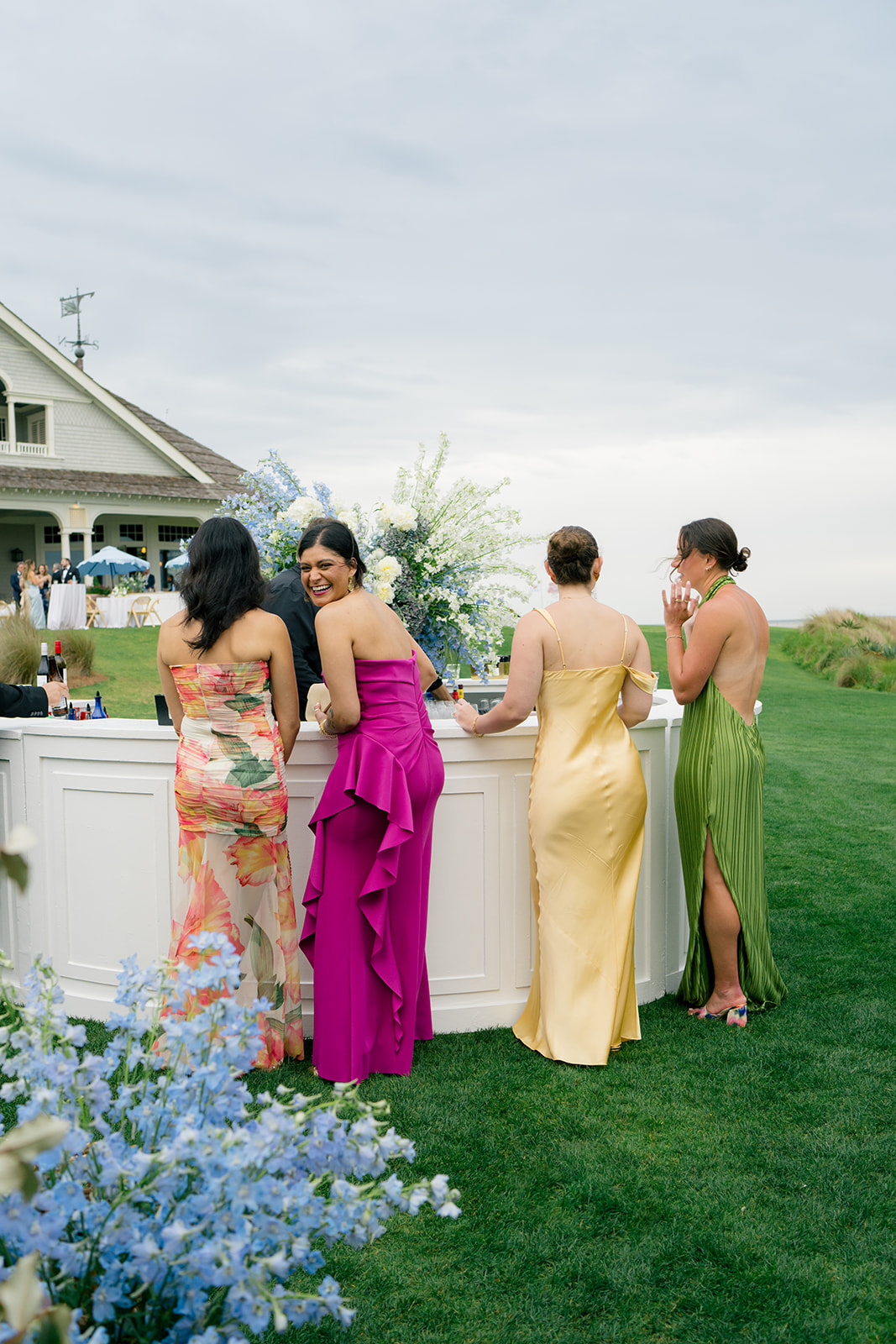 Girl at the bar in purple dress turning around and laughing.