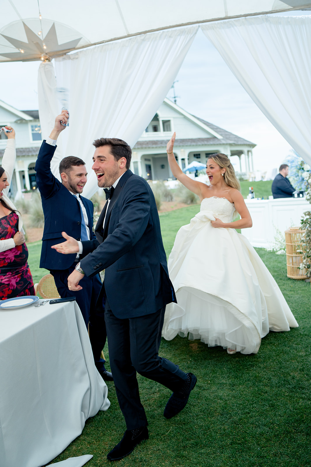 Bride and groom high five wedding guests. 