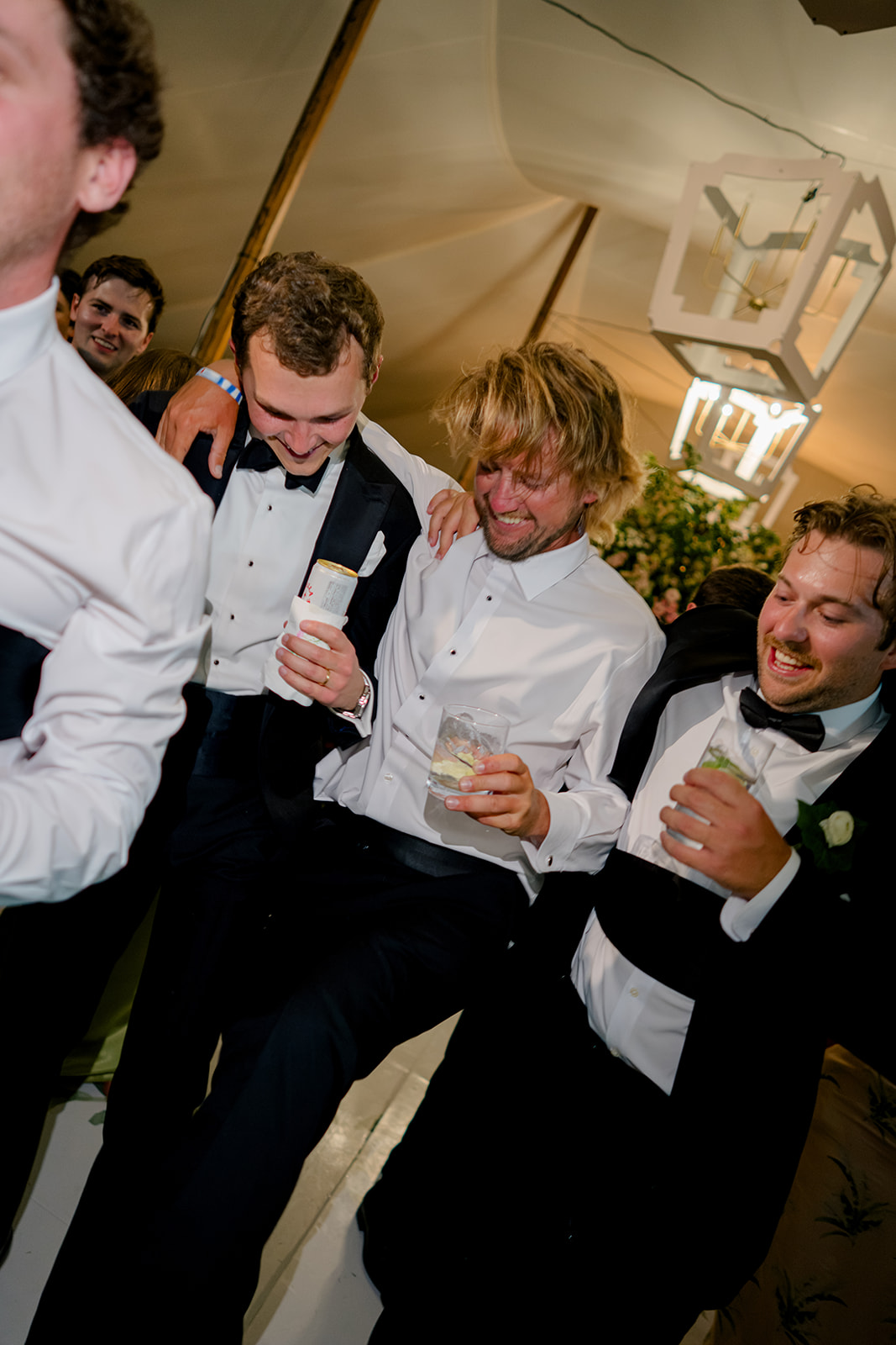 Groom dances with his friends during wedding reception. 